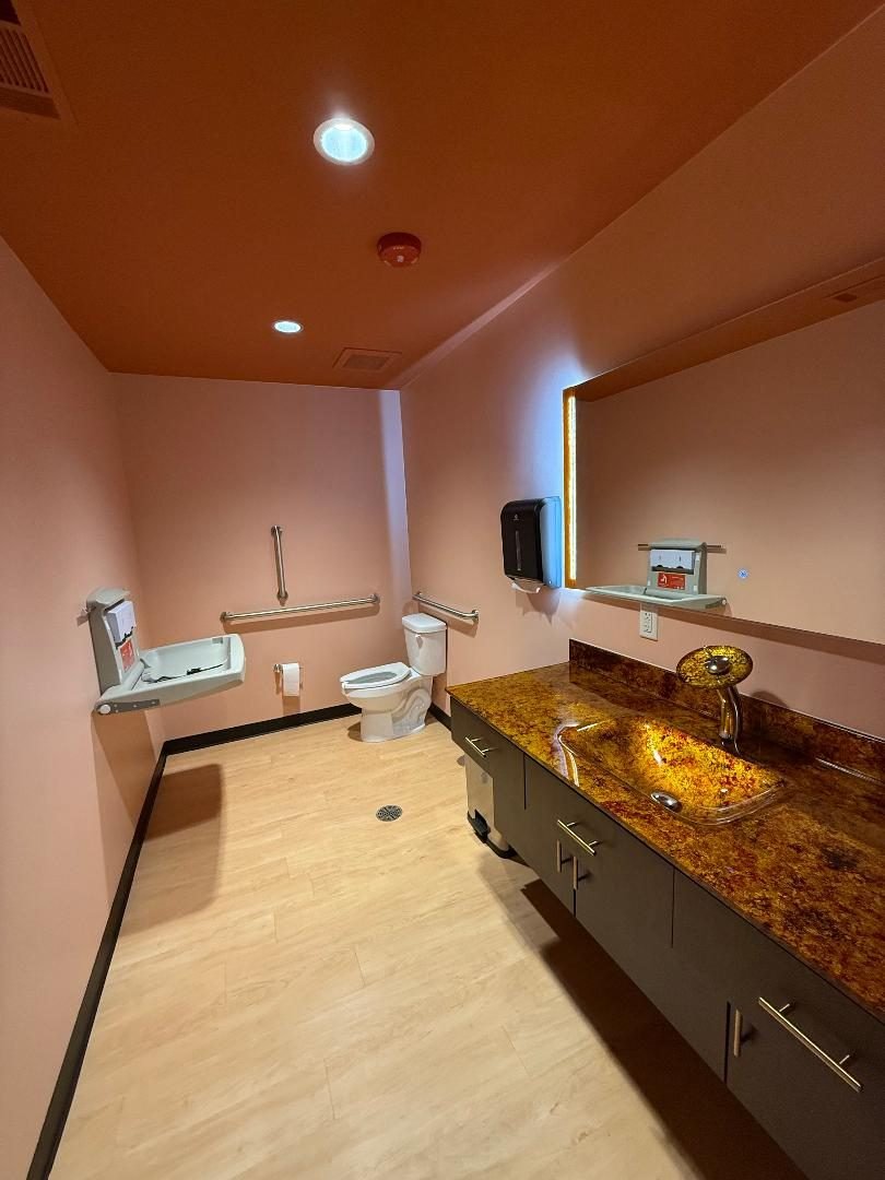 The accessible Prime Health restroom with grab bars and a baby changing station